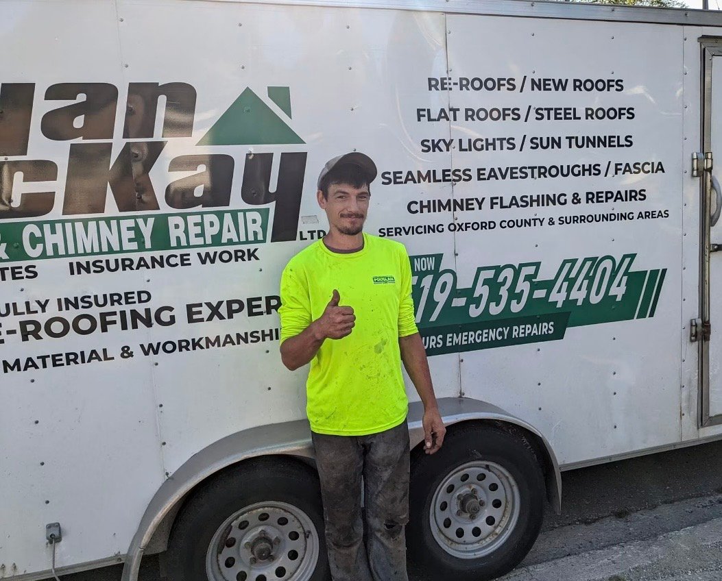 Ryan McKay standing beside the Ryan McKay Roofing work trailer